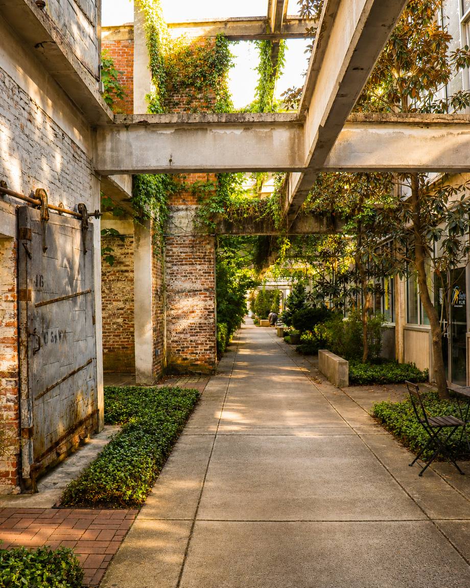 A quiet garden nook beside a preserved metal door, a bench tucked under the trees
